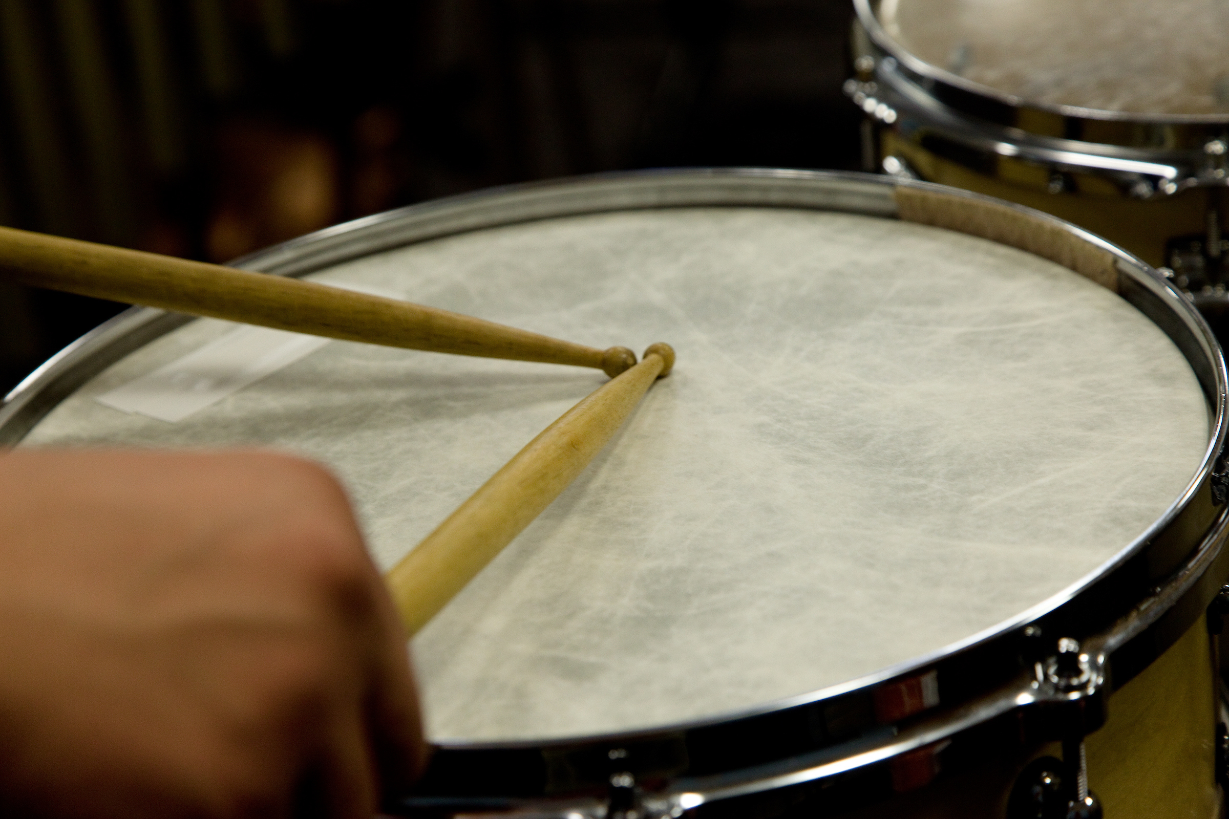 Drummer hits drum with drumsticks