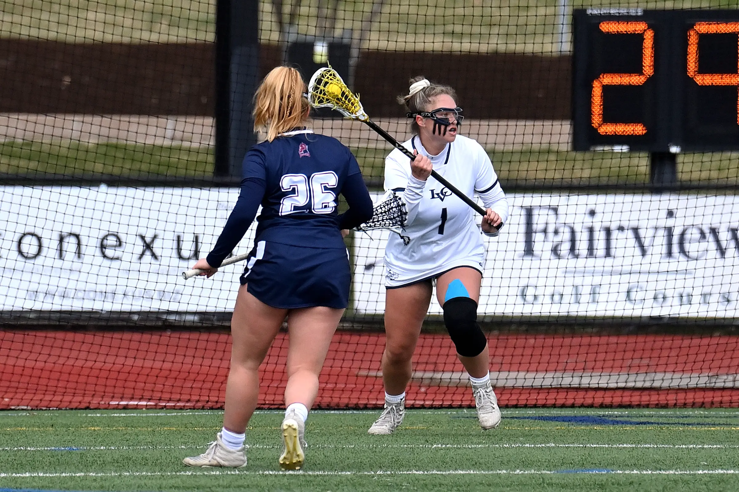 An LVC women's lacrosse player stands on the field.