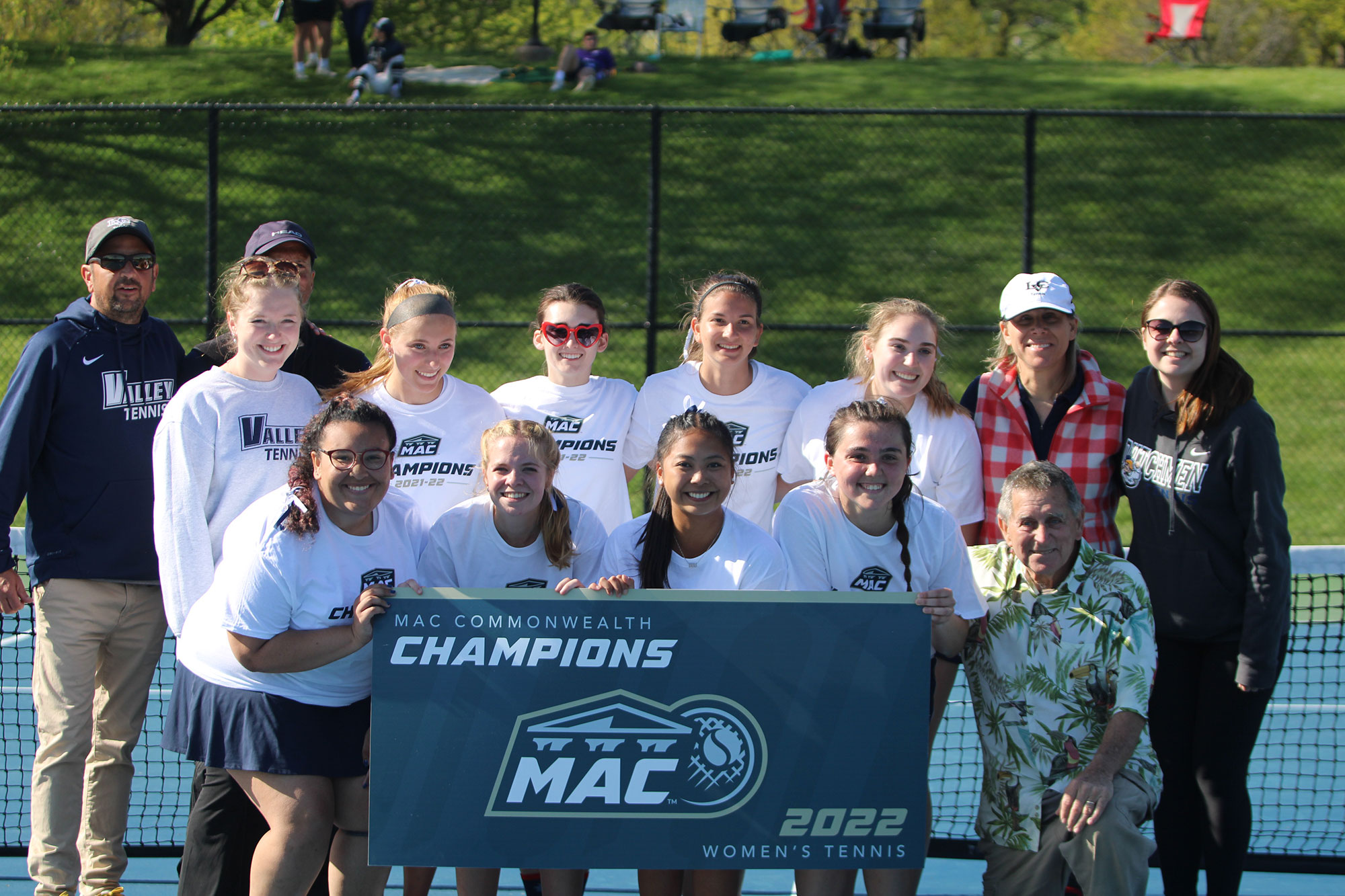 women's tennis team with conference championship banner