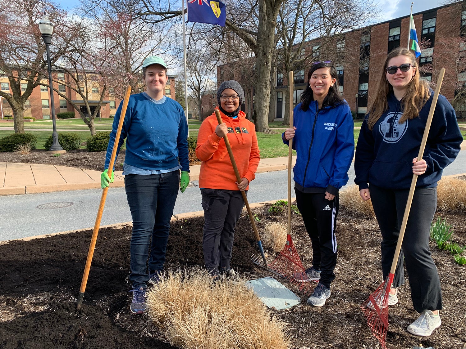 Students spread mulch as part of a campus cleanup.