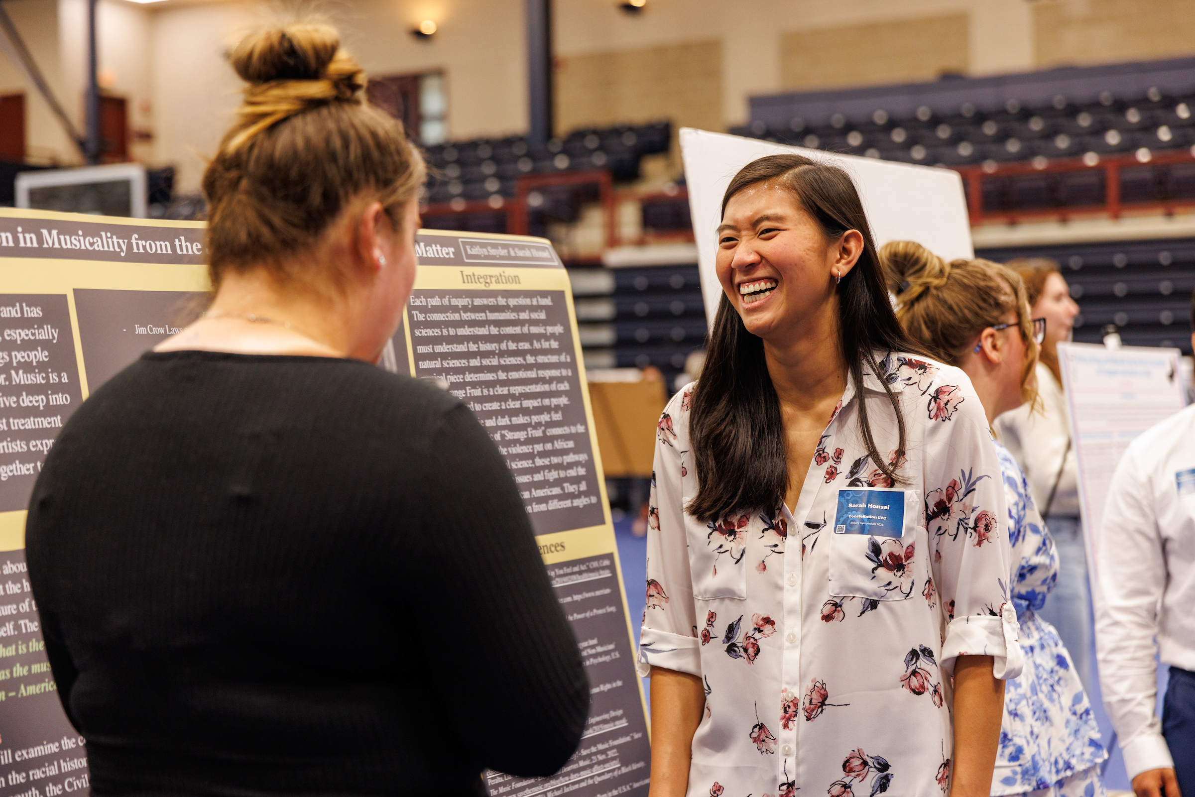 Students discuss research display at Inquiry Symposium