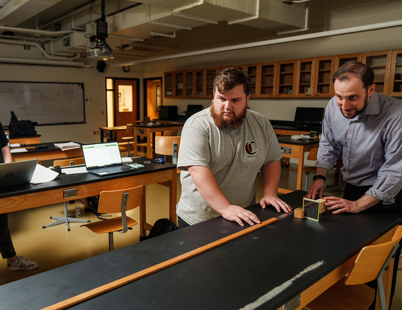 Dr. Dan Pitonyak works with student in the physics lab.