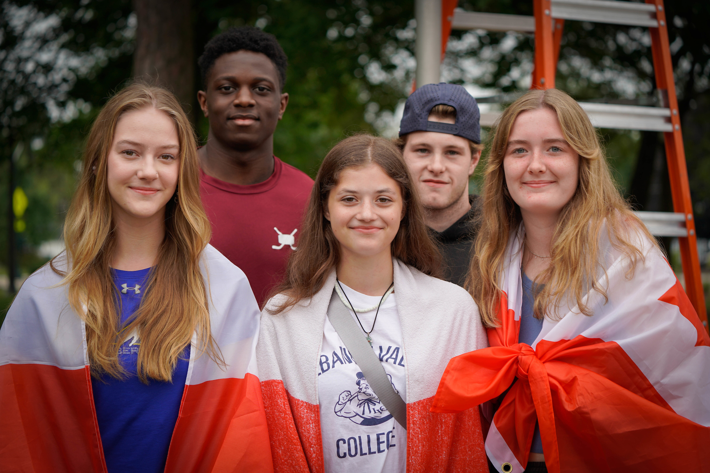 International student flag-raising during orientation fall 2023. L-R: Jorja Fisher, Maeghan Howson, Lacy Bigelow. Justin Davis, Troy Andrews