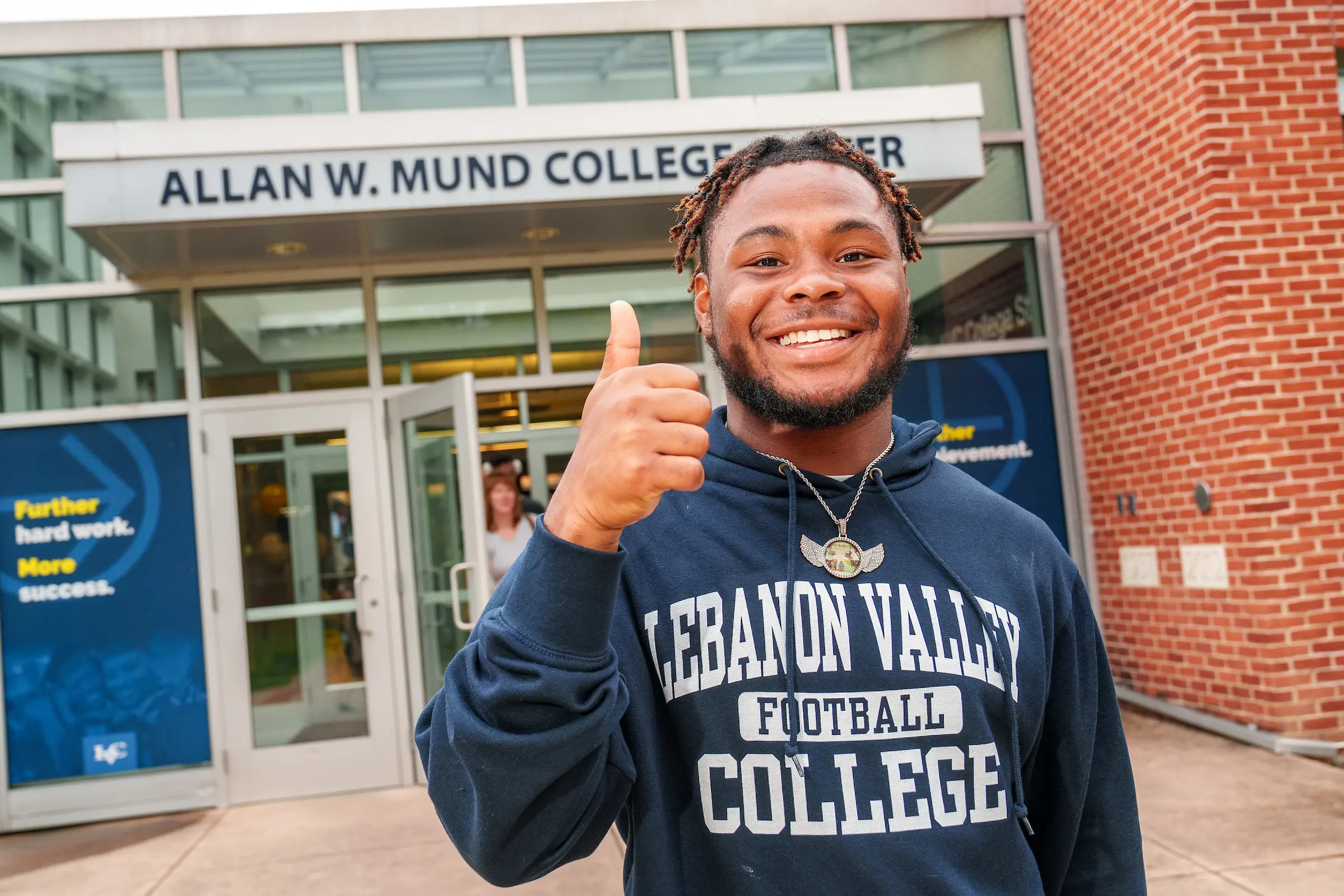 LVC student and football player poses in front of Mund College Center
