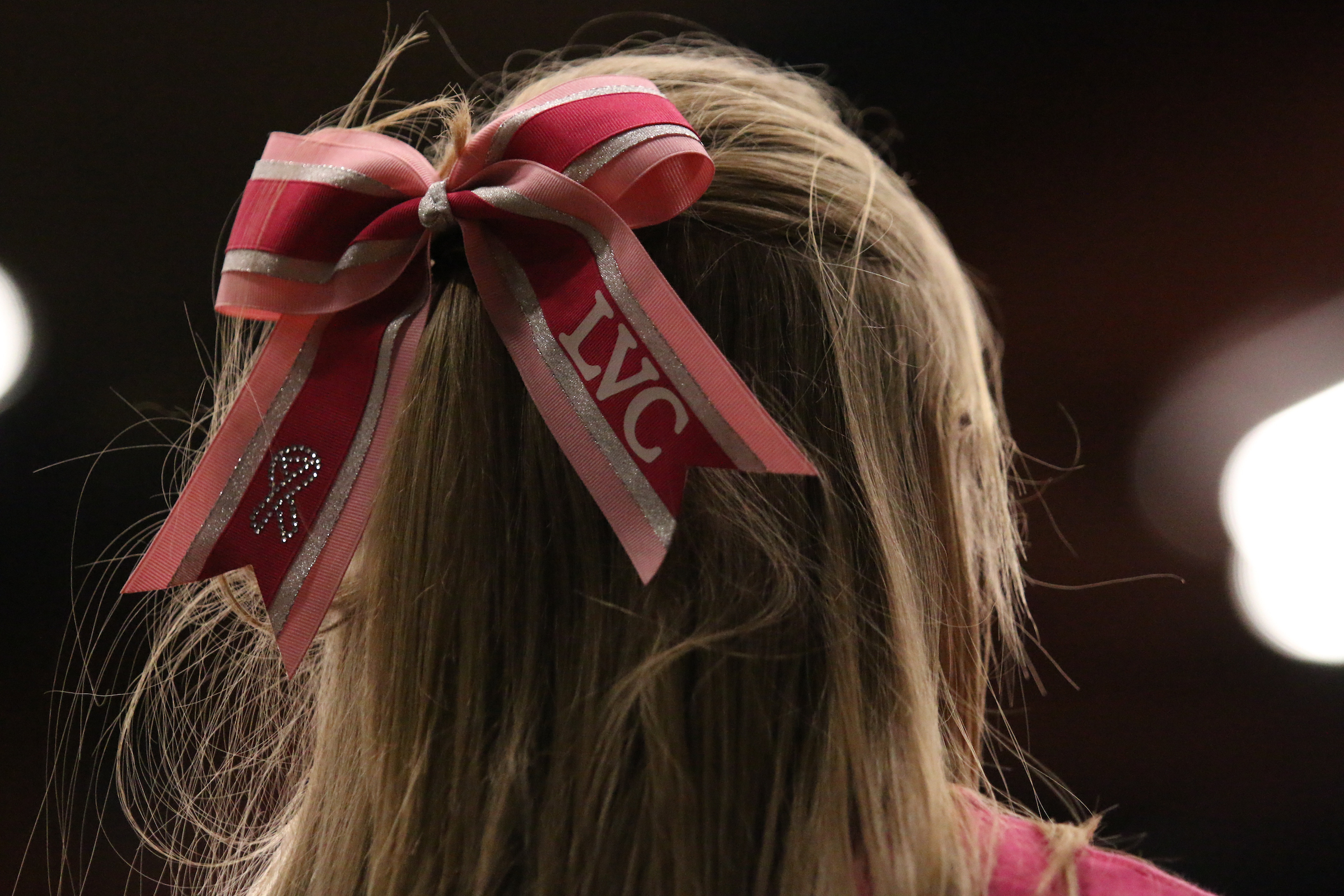 Pink LVC bow in student's hair at women's basketball Pink Game.