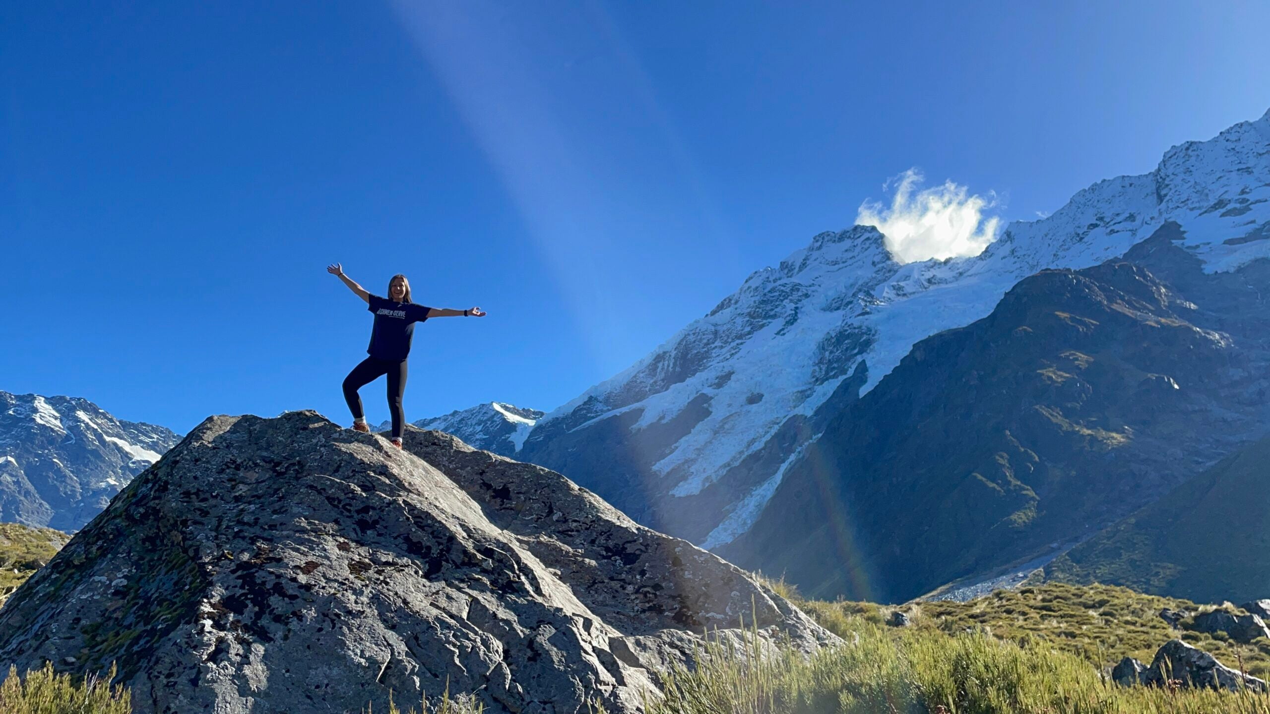 LVC student Alex stands on boulder in New Zealand