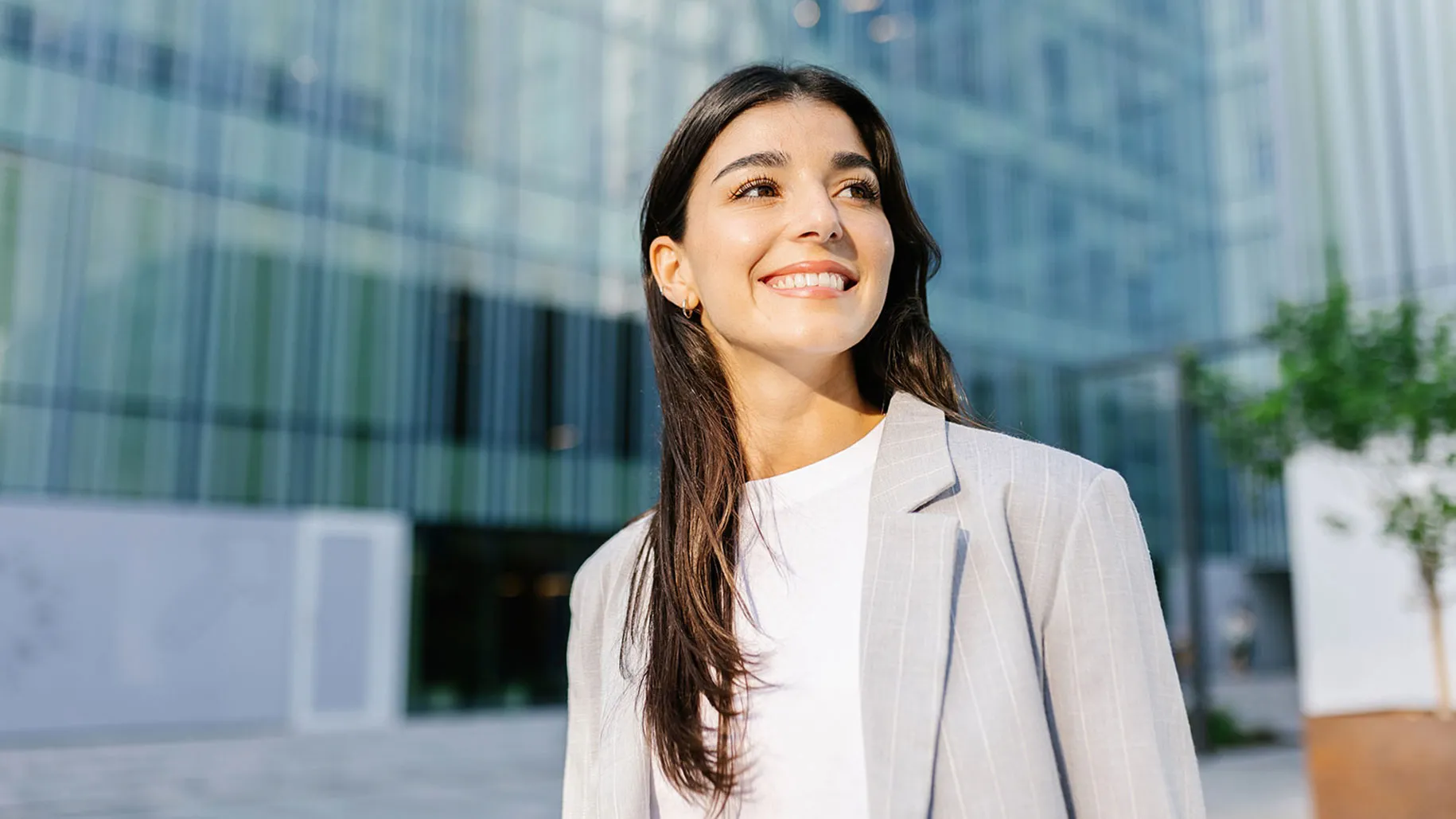Young woman in business attire in front of building