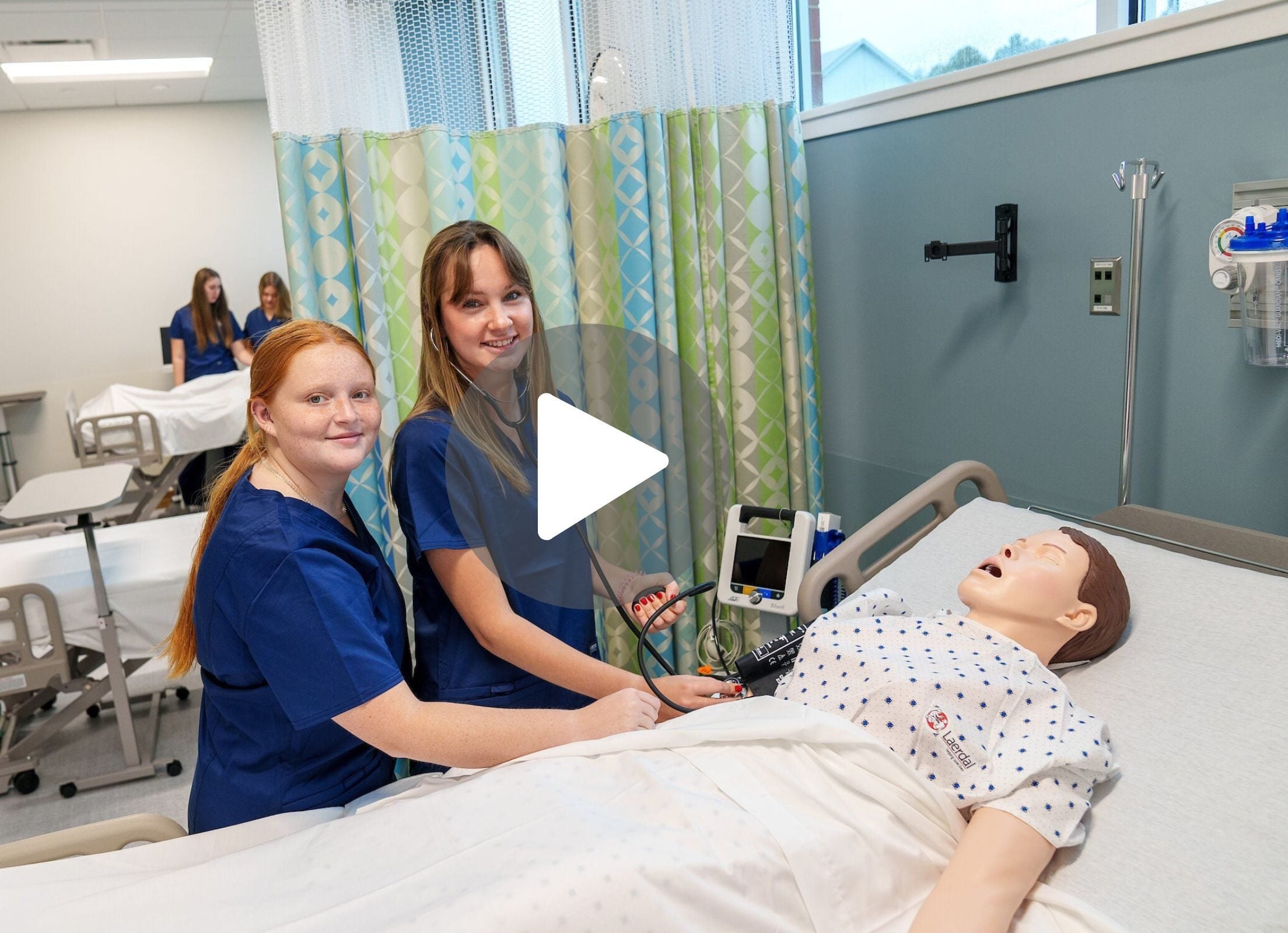 LVC nursing students in simulation lab with video button to click