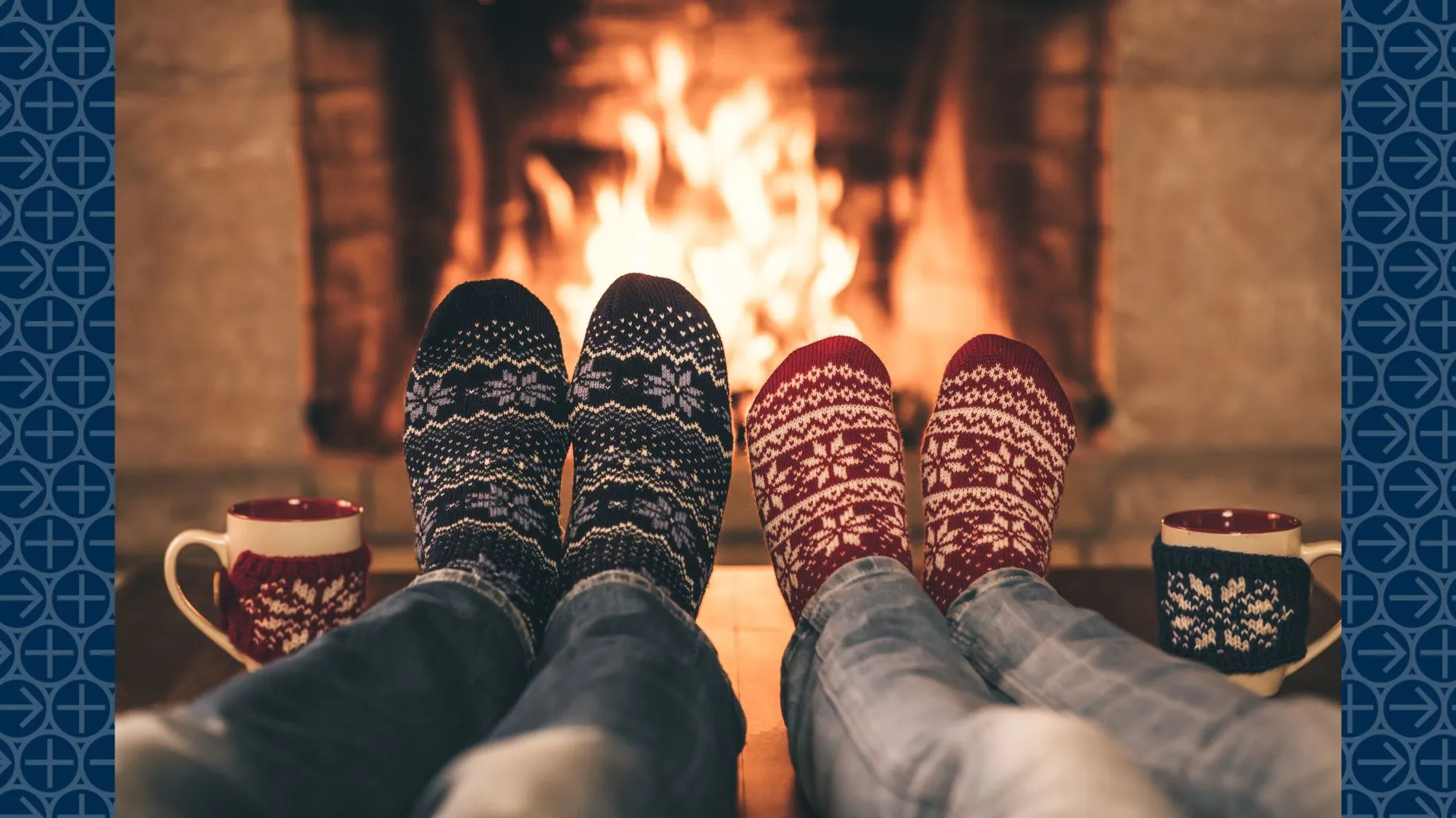 People sit in front of fire with holiday socks and mugs