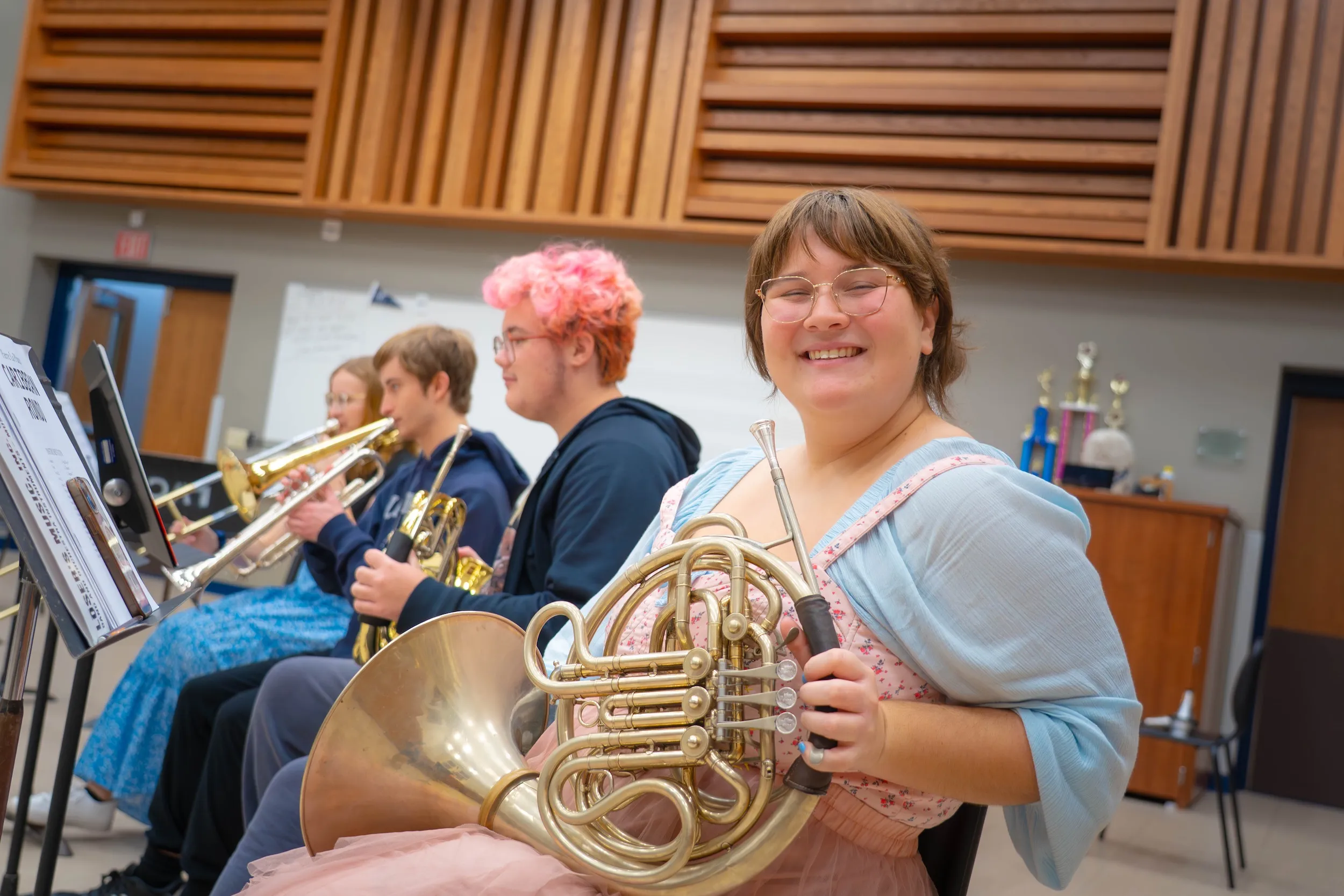 Student smiles with instrument during band practice