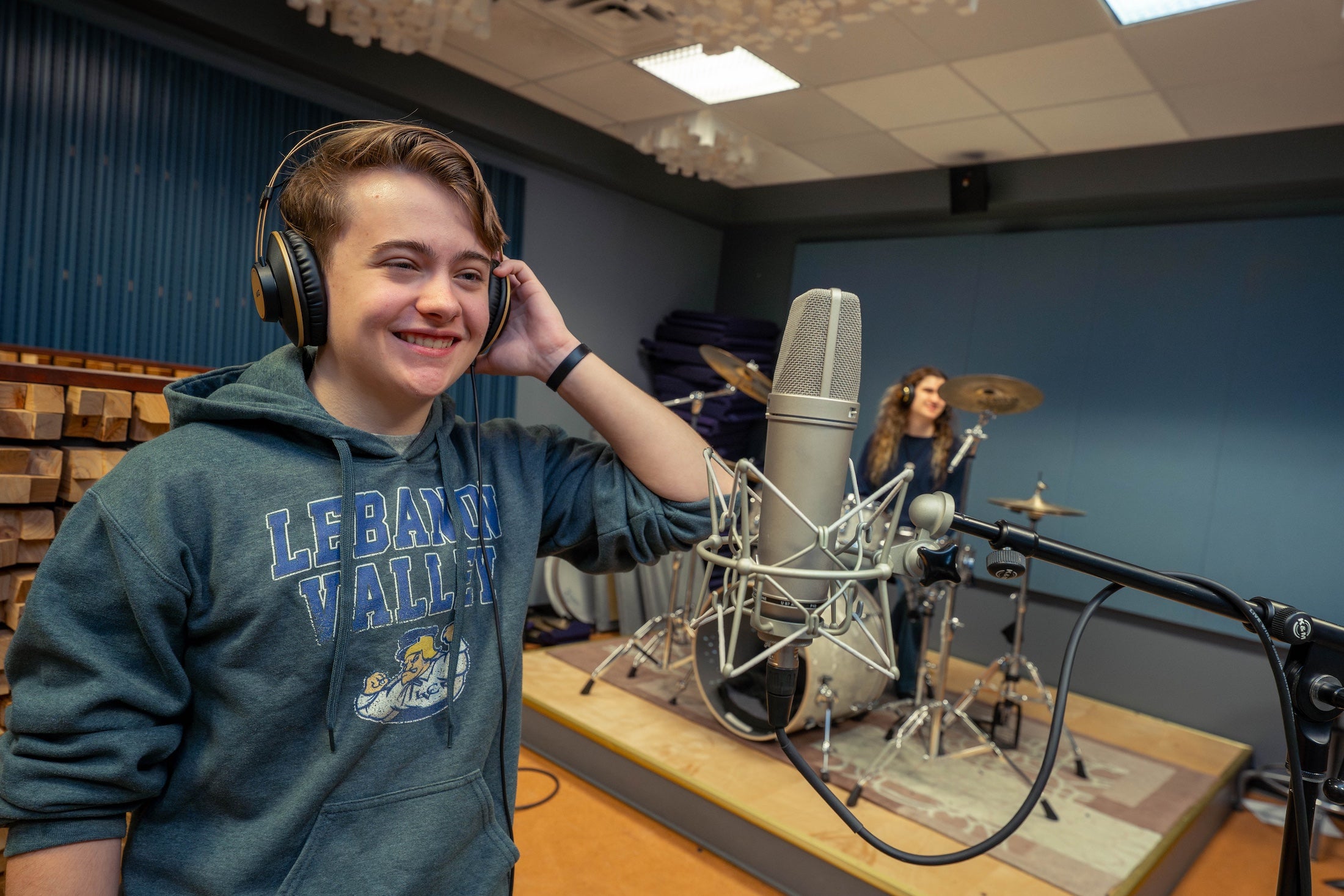 Student stands at microphone in music production studio