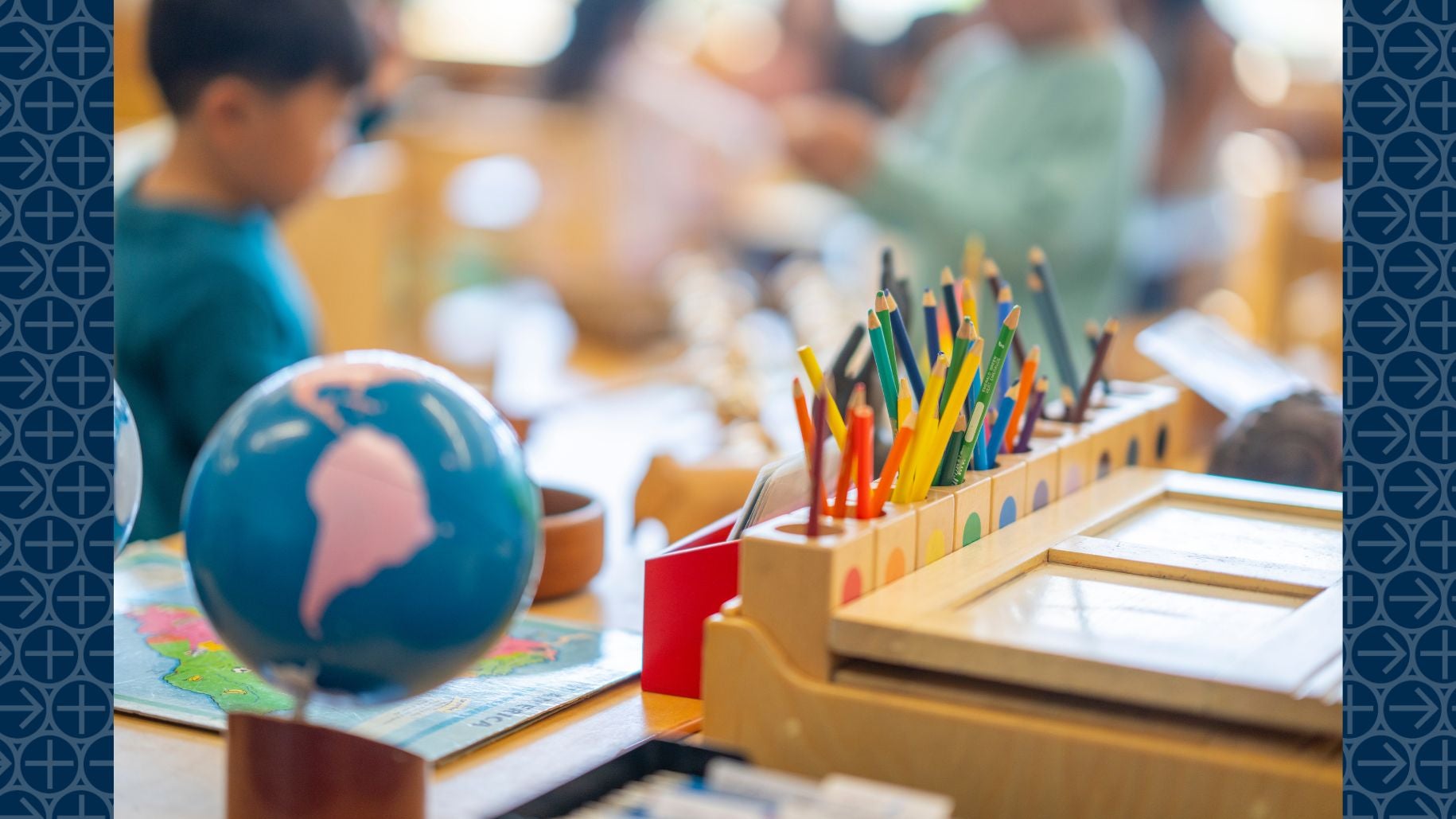 Colored pencils and globe on classroom desk