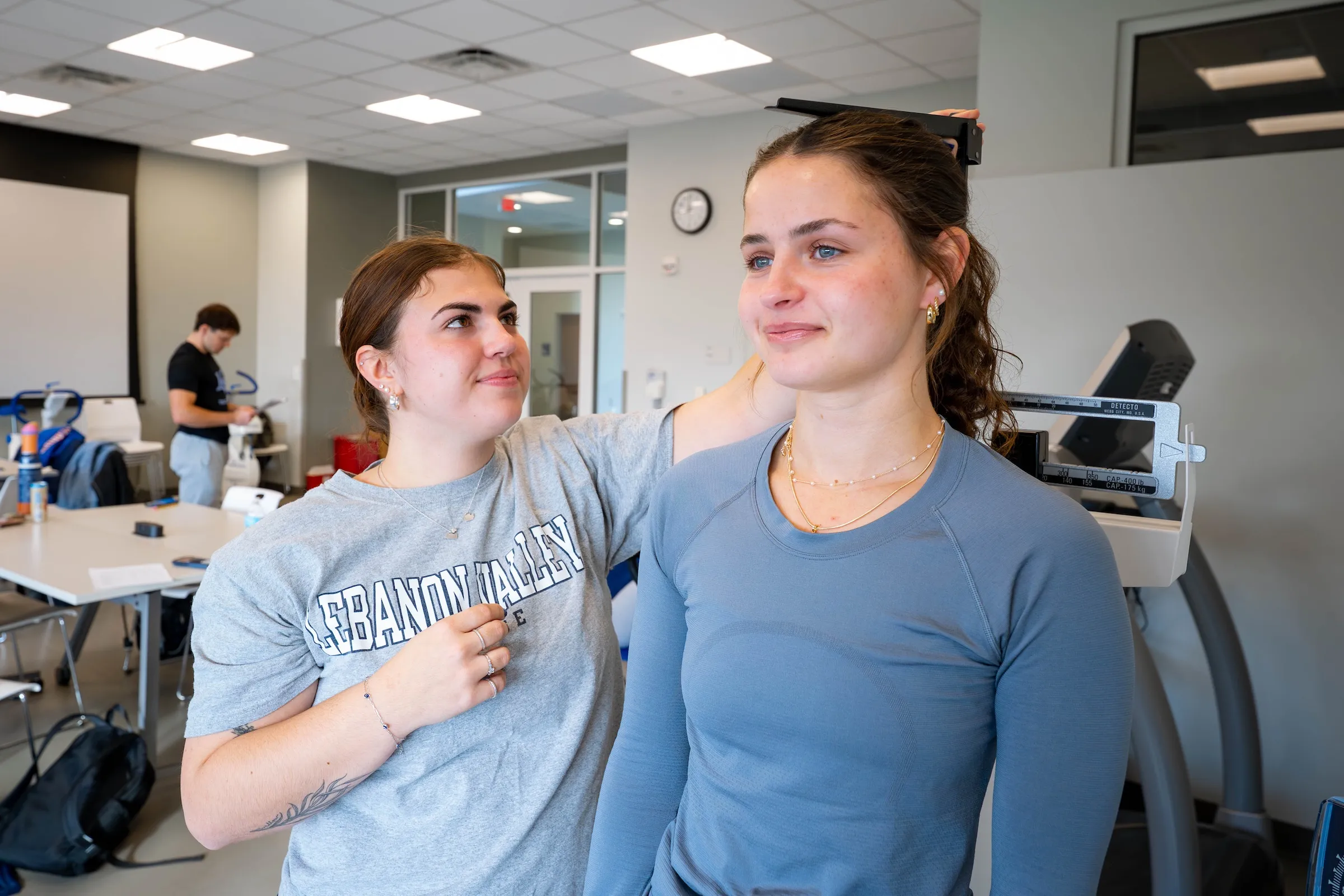 Exercise science student measures height of fellow student