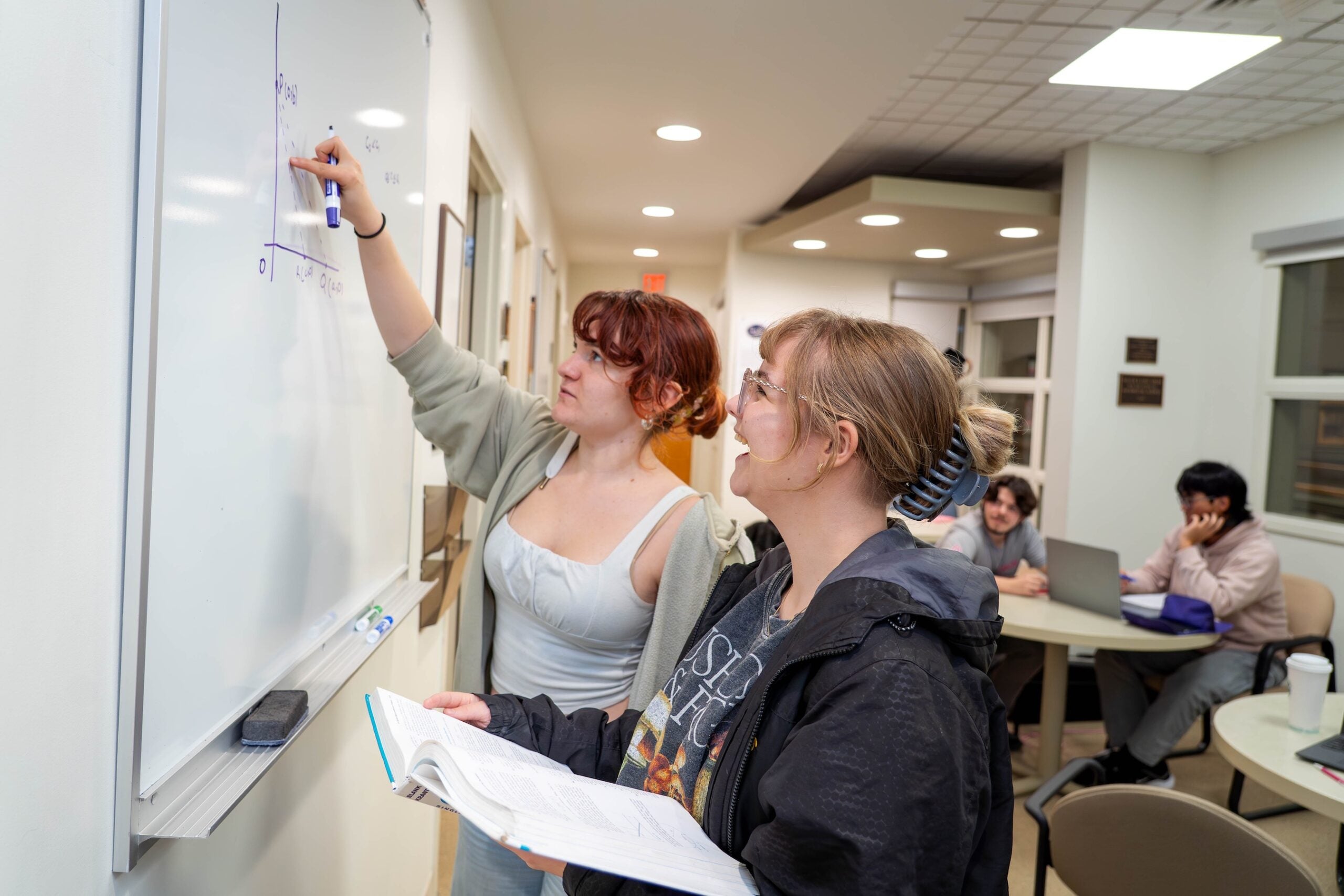 Students write on white board in mathematics space