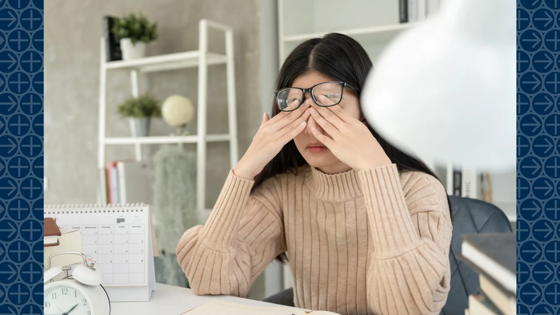 Woman rubs eyes in frustration while sitting at desk