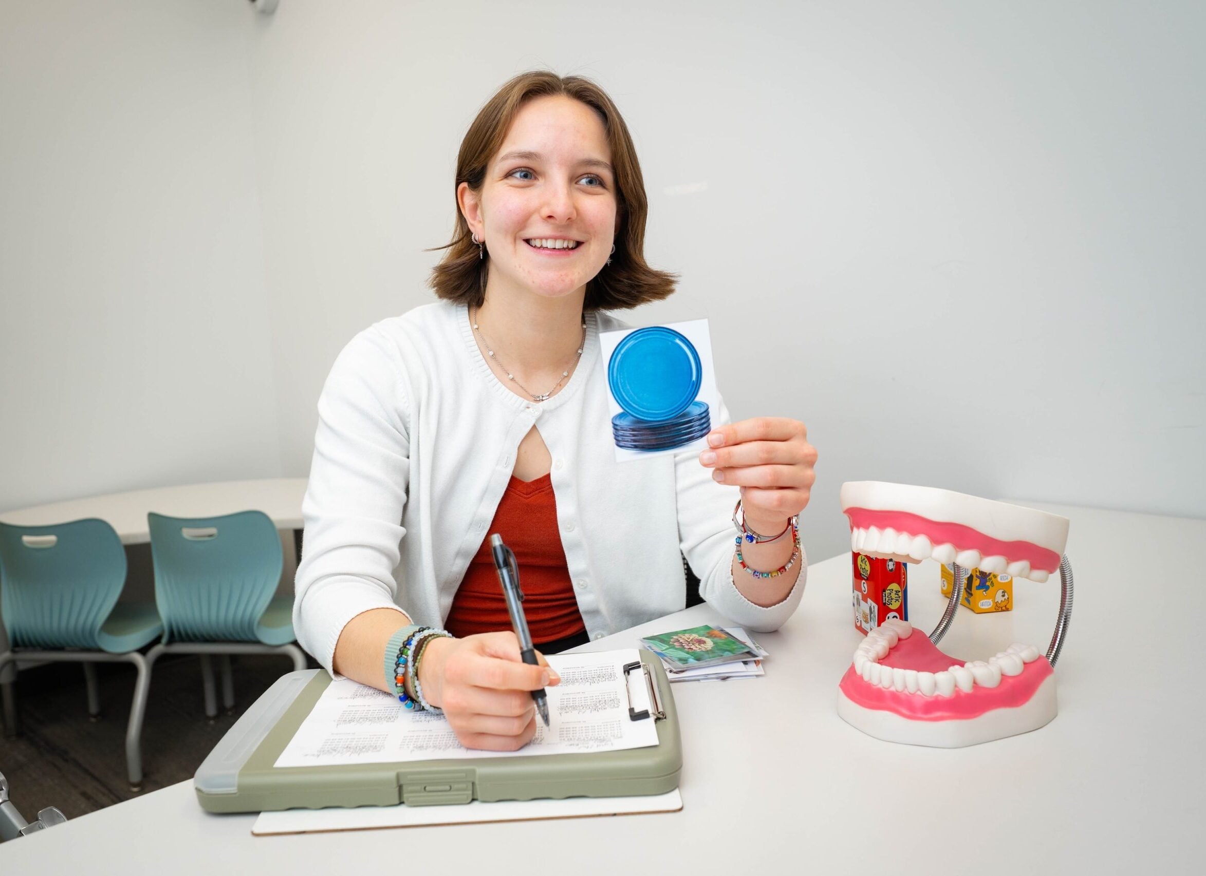 LVC speech-language pathology student holds up card while working with patient at Center for Speech, Language, & Hearing Disorders