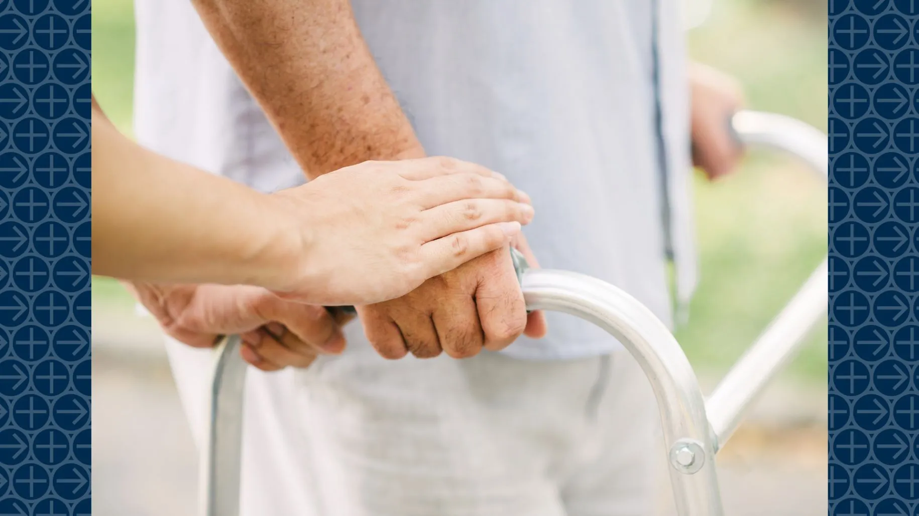 Hands of caregiver assisting person with walker