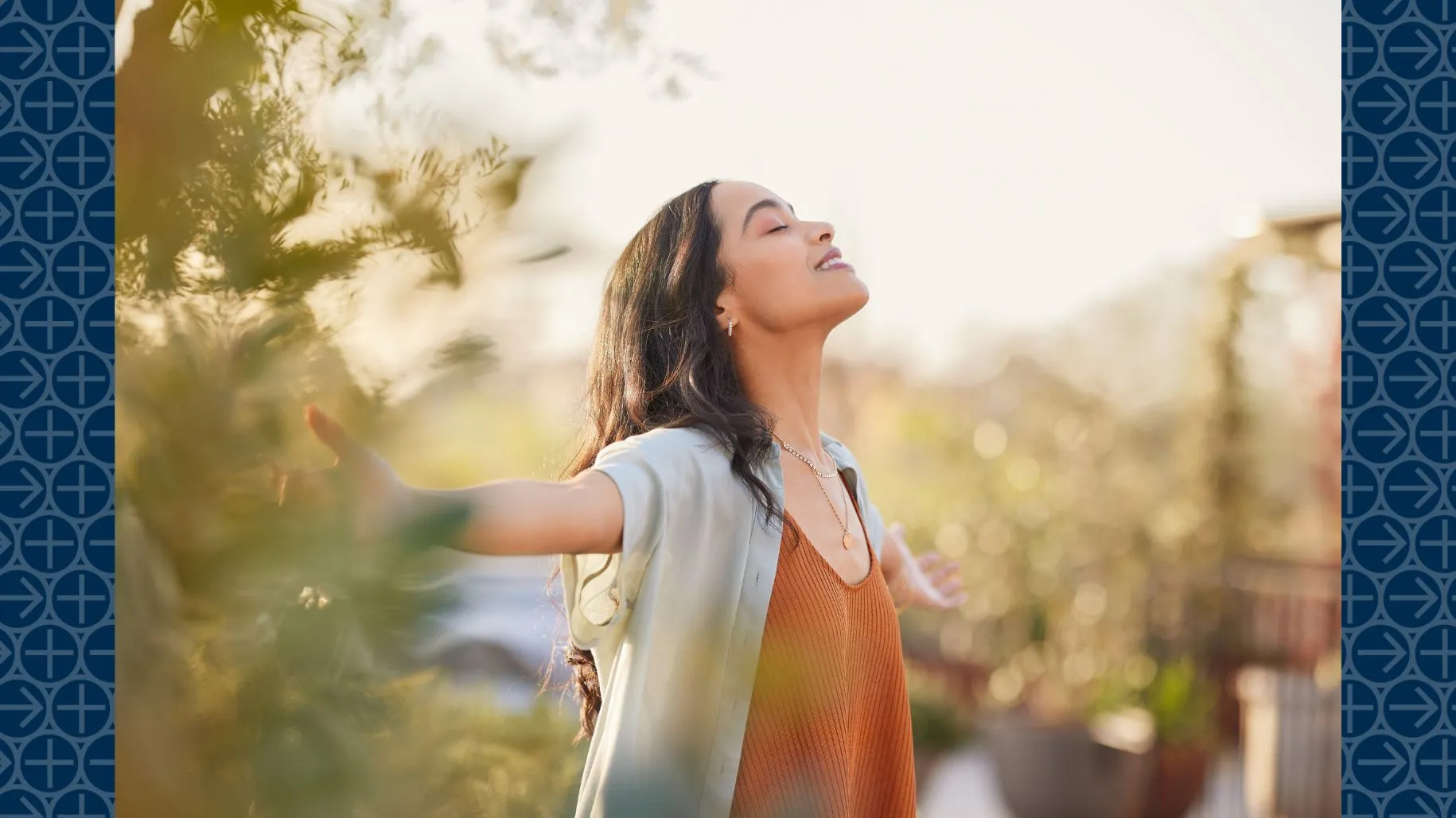 Woman smiling with eyes closed and arms opens facing up toward sky