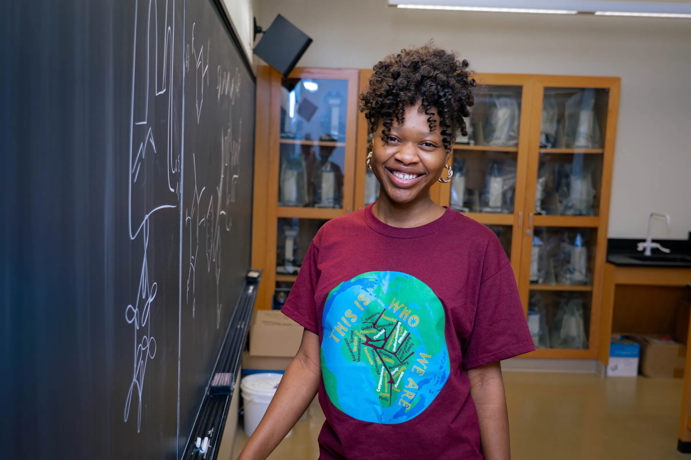 Neuroscience student Farida Tassiou stands at chalkboard