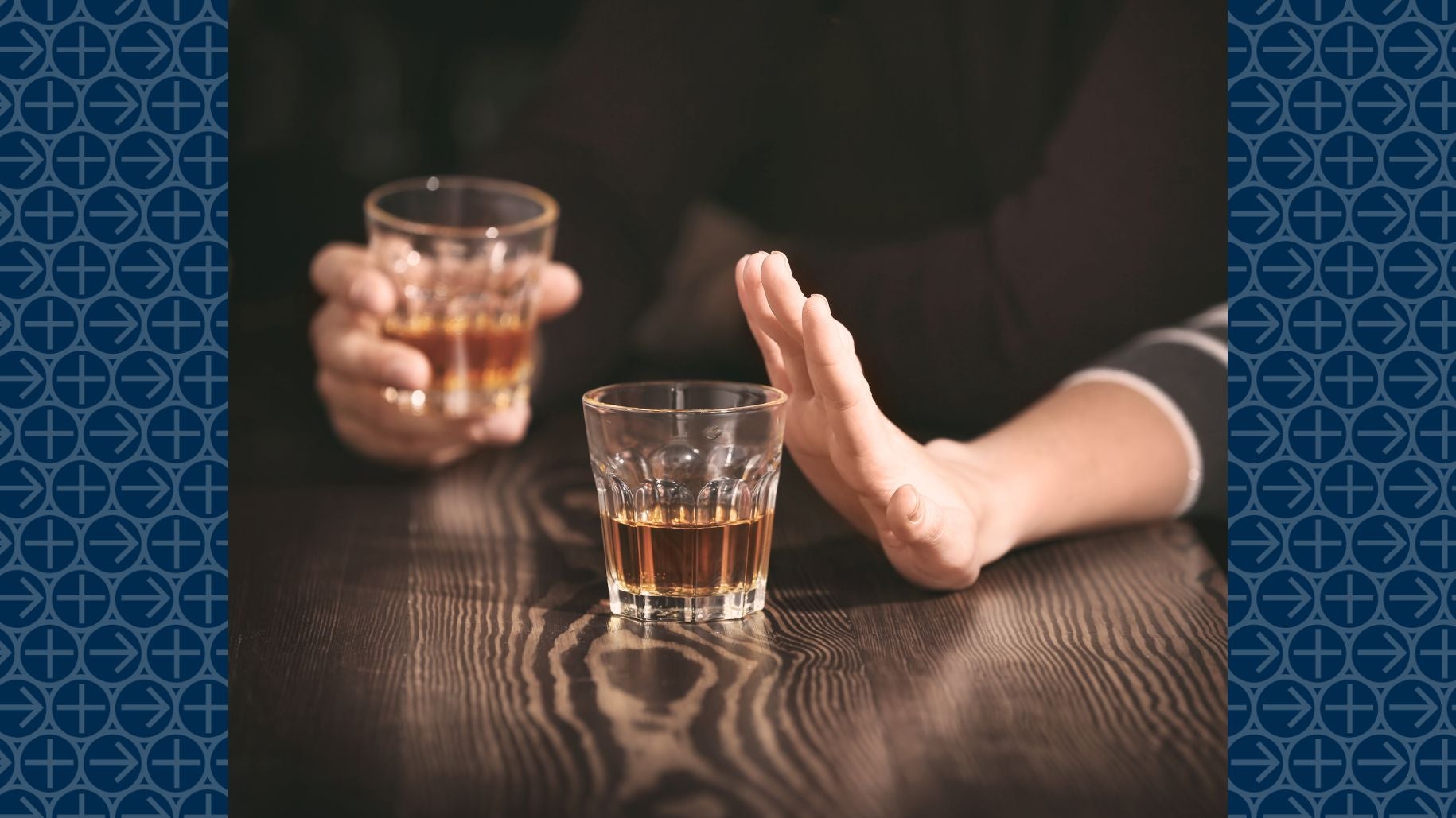 Hand pushes away glass of alcohol on table