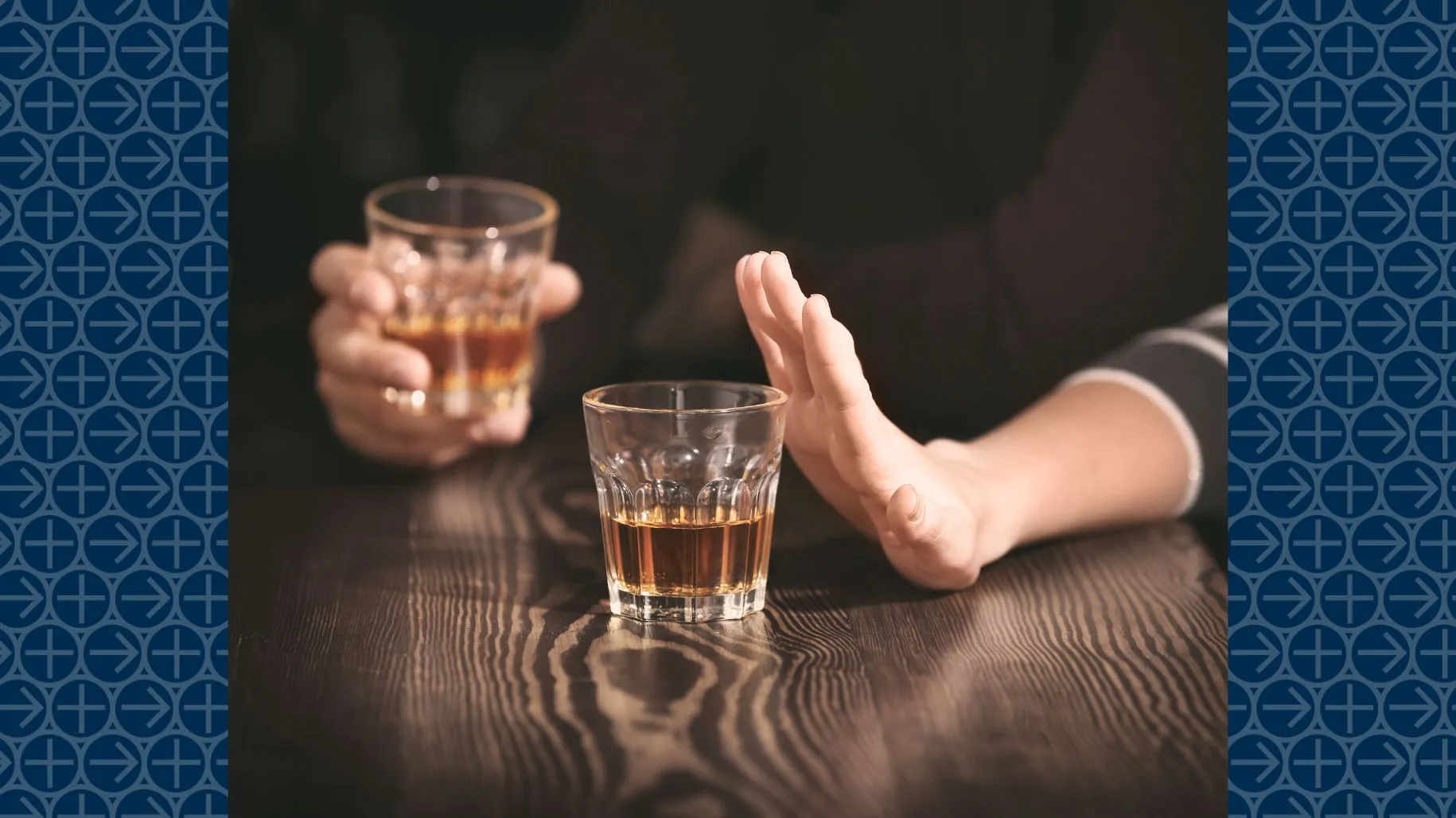 Hand pushes away glass of alcohol on table