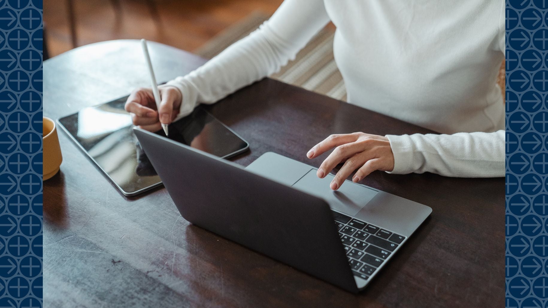 Woman works on laptop and tablet at desk