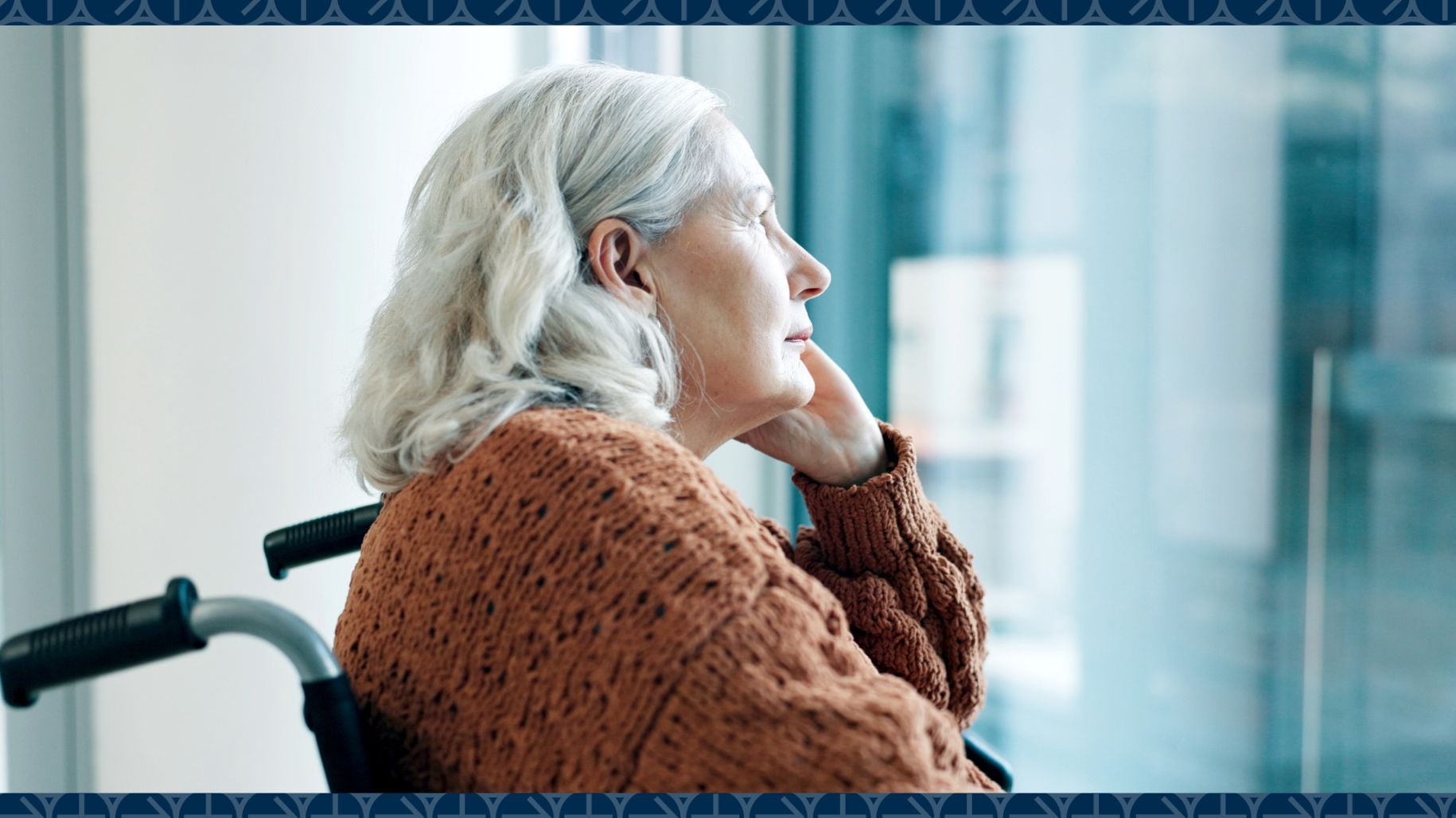 Woman sitting in wheelchair looks out window