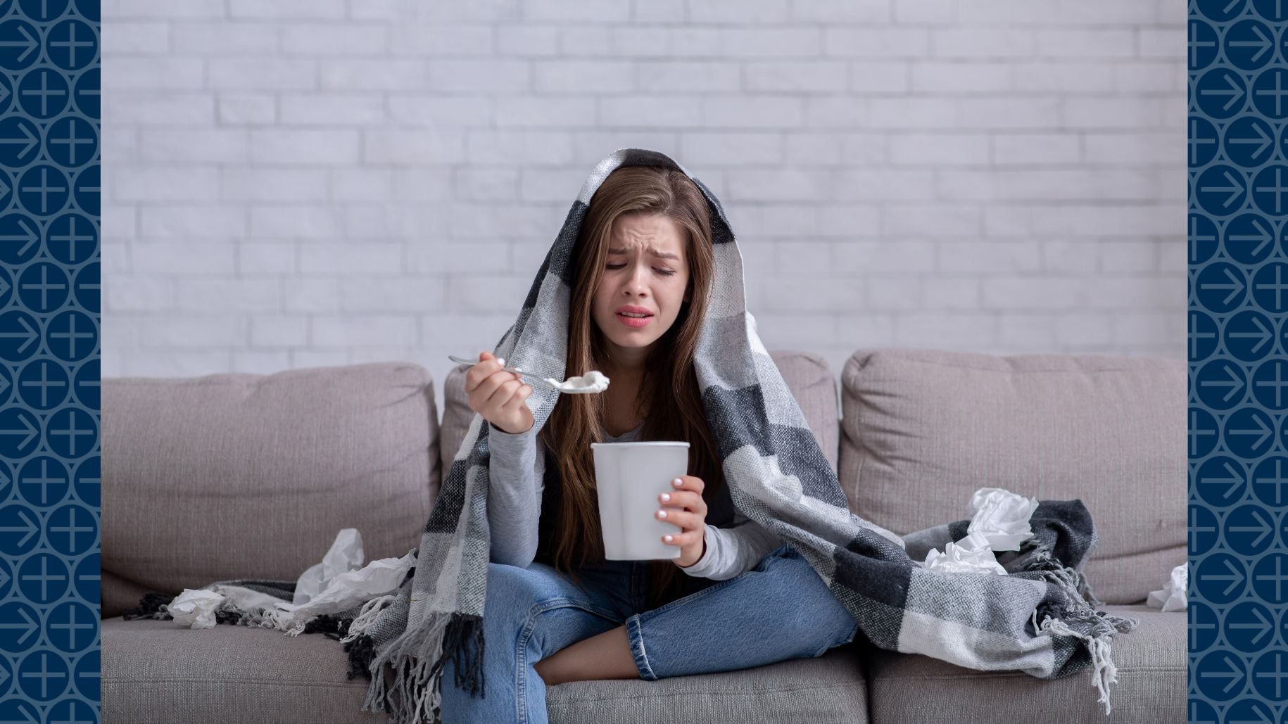 Young woman eats ice cream on couch while looking stressed