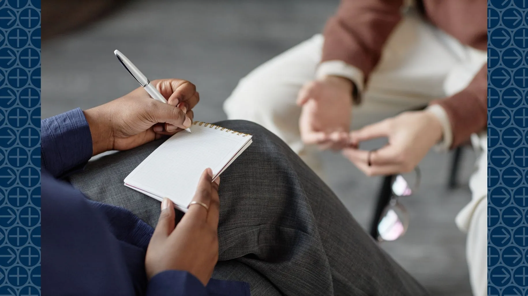 Counselor writes on notepad while meeting with patient